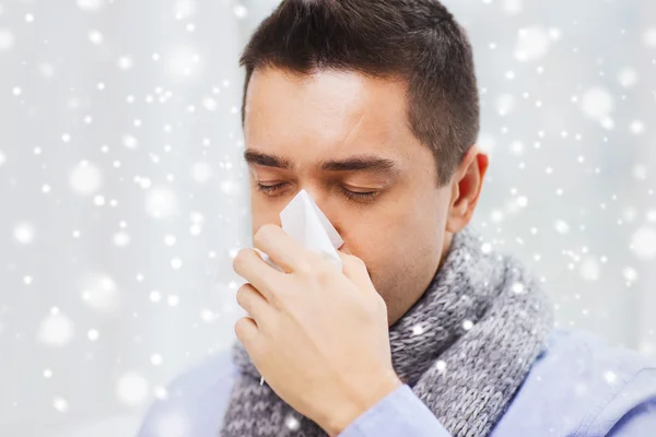 Close up de homem doente com gripe soprando nariz em casa Imagens De Bancos De Imagens