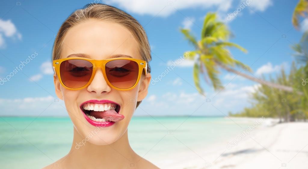 Fotos de Mujer joven feliz en gafas de sol mostrando la lengua - Imagen de  © Syda_Productions #92428782