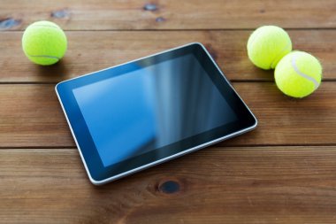 close up of tennis balls and tablet pc on wood clipart