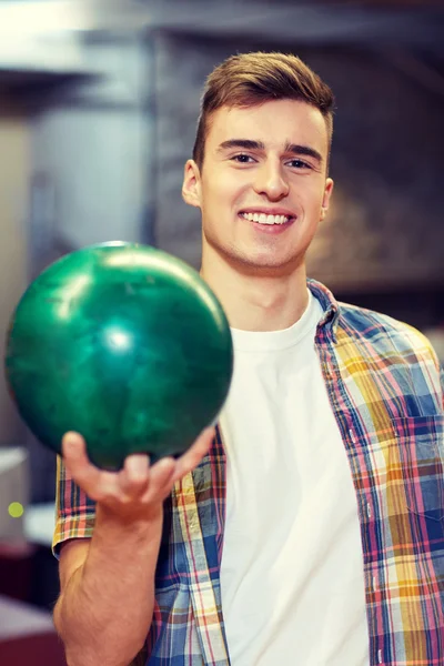 Heureux jeune homme tenant la balle dans le club de bowling — Photo
