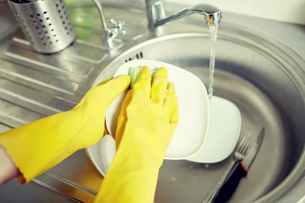 Gros plan de femme mains laver la vaisselle dans la cuisine — Photo