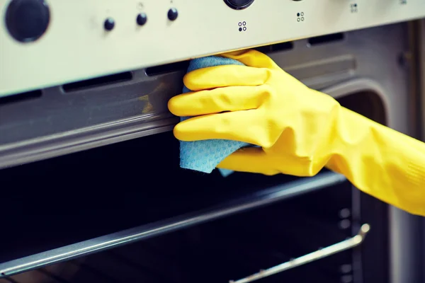 Närbild på kvinna rengöring ugn hemma kök — Stockfoto