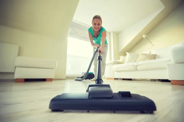 Femme heureuse avec aspirateur à la maison — Photo