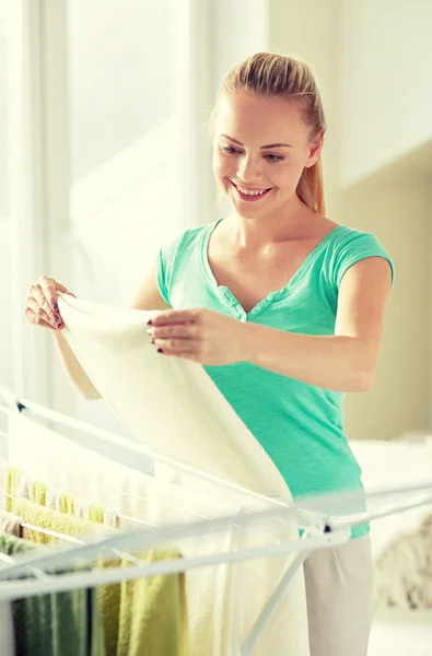 Happy woman hanging clothes on dryer at home — Stock Photo, Image