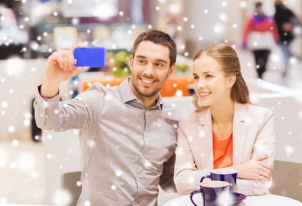 Gelukkige paar met smartphone nemen selfie in winkelcentrum — Stockfoto