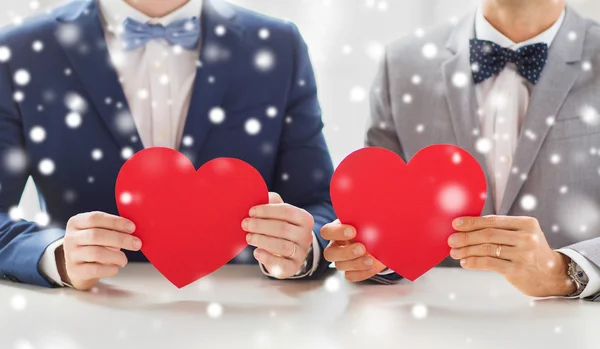 Close up de masculino gay casal segurando vermelho corações — Fotografia de Stock