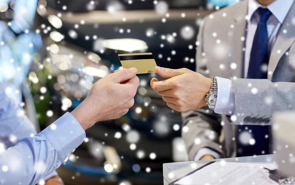 Cliente que da la tarjeta de crédito al distribuidor del coche en salón — Foto de Stock