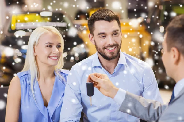 Happy couple with car dealer in auto show or salon — Stock Photo, Image