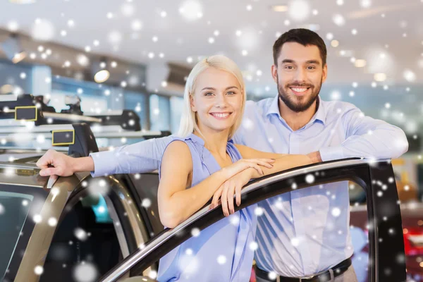 Couple heureux avec voiture en salon ou salon de l'auto — Photo