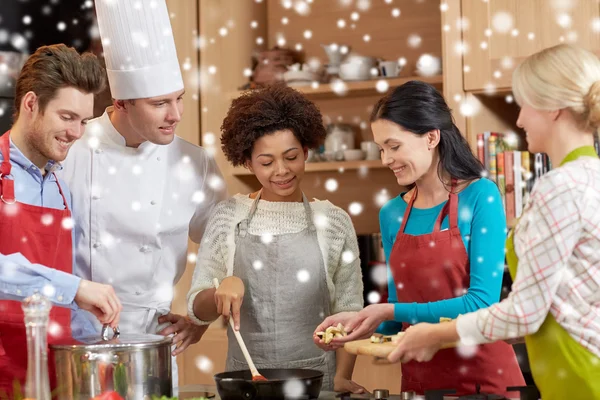 Glückliche Freunde und Koch kochen in der Küche — Stockfoto
