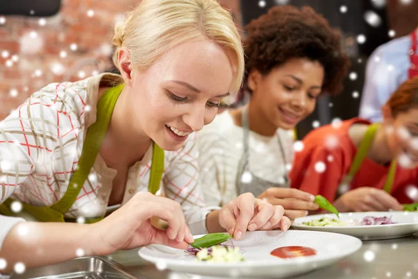 Šťastné ženy, vaření a zdobení jídel — Stock fotografie