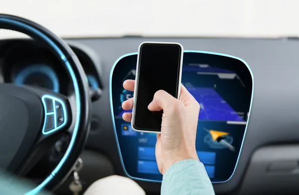 男性的手密切联系驾驶汽车的智能手机 — 图库照片