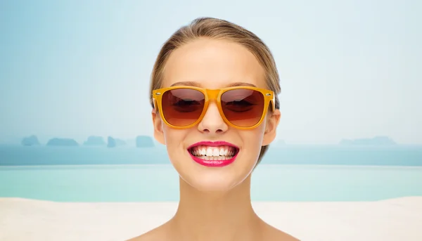 Glückliche junge Frau mit Sonnenbrille und rosa Lippenstift — Stockfoto