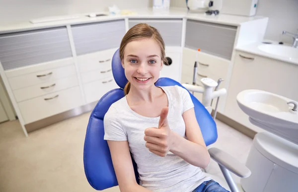 Menina paciente feliz mostrando polegares para cima na clínica — Fotografia de Stock