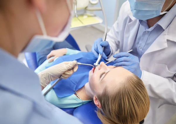 Närbild på tandläkare behandla kvinnlig patient tänder — Stockfoto