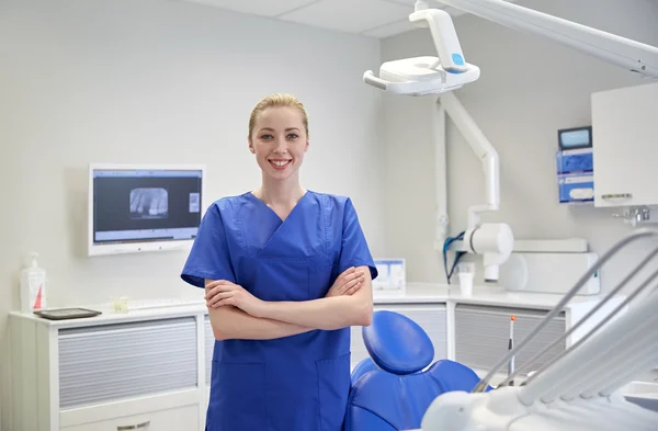 Gelukkig jonge vrouwelijke tandarts bij tandheelkundig kliniek kantoor — Stockfoto