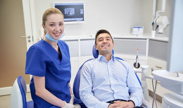 Mutlu kadın dişçi klinikte adam hastayla — Stok fotoğraf