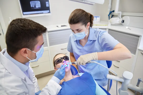 Dentistas tratando os dentes dos pacientes do sexo masculino na clínica — Fotografia de Stock