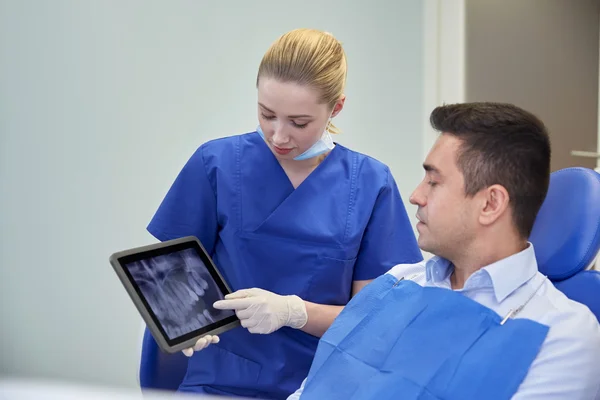 Dentista femminile con tablet pc e paziente maschile — Foto Stock