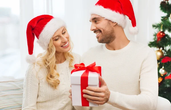 Feliz pareja en casa con caja de regalo de Navidad — Foto de Stock