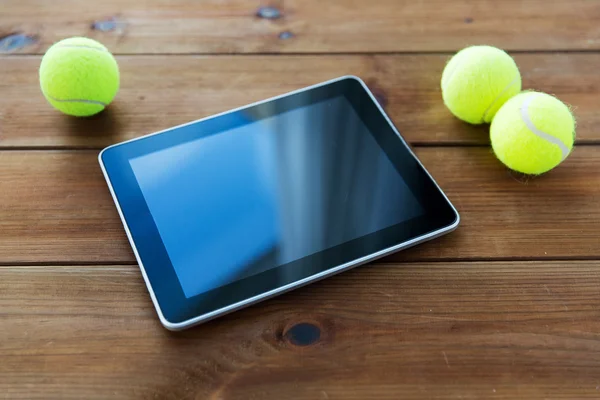 Primo piano di palline da tennis e tablet pc su legno — Foto Stock