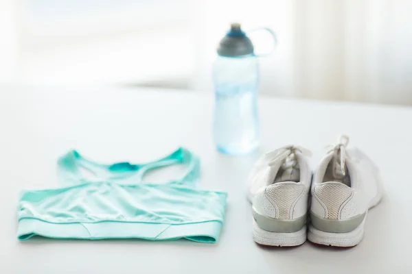 Close up de roupas esportivas femininas e conjunto de garrafas — Fotografia de Stock