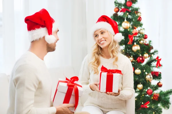 幸せなカップル自宅のクリスマス プレゼントを交換 ロイヤリティフリーのストック写真