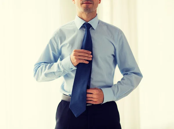 Primer plano del hombre en camisa ajustando corbata en el cuello — Foto de Stock