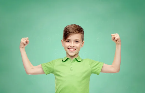 Счастливый мальчик в футболке с поло, демонстрирующий крепкие кулаки — стоковое фото