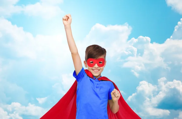 Boy in red superhero cape and mask showing fists — Stock Photo, Image