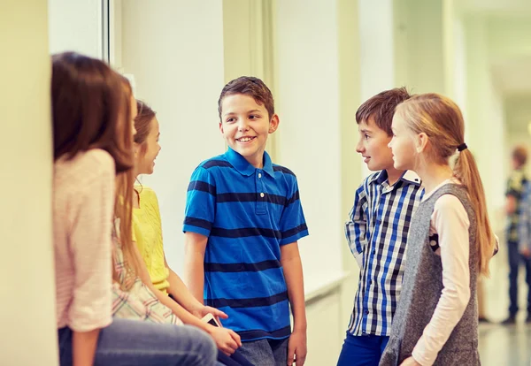 Groupe d'écoliers souriants parlant dans le couloir — Photo