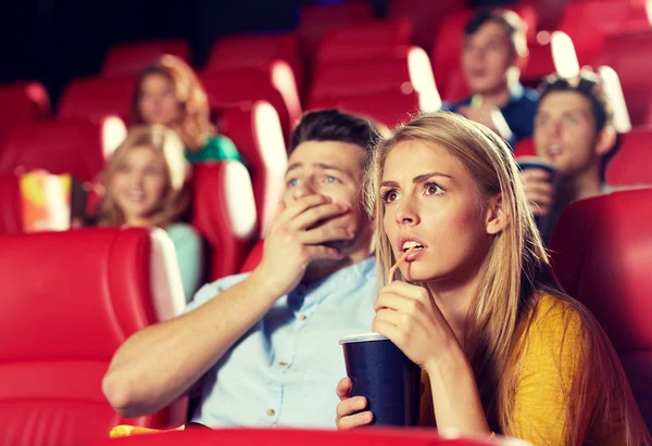 Vrienden kijken naar horrorfilm in theater — Stockfoto