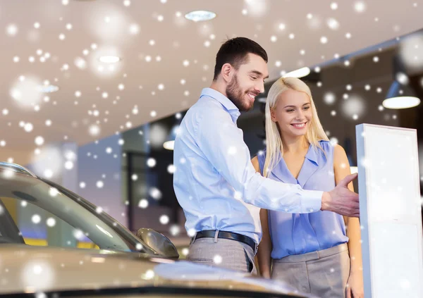 Feliz pareja comprando coche en auto show o salón —  Fotos de Stock