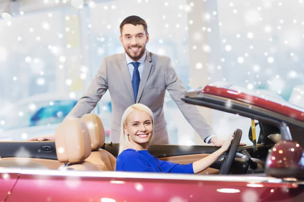 Feliz pareja comprando coche en auto show o salón —  Fotos de Stock