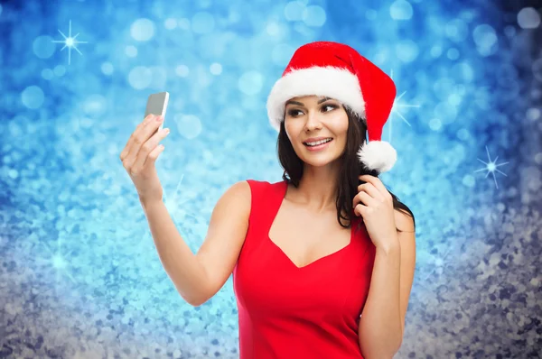 Woman in santa hat taking selfie by smartphone — Stock Photo, Image