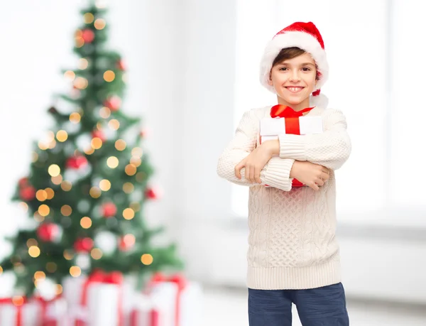 Smiling happy boy in santa hat with gift box — Stock Photo, Image