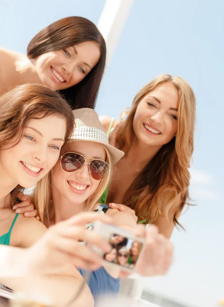 Улыбающиеся девушки фотографируются в кафе на пляже — стоковое фото