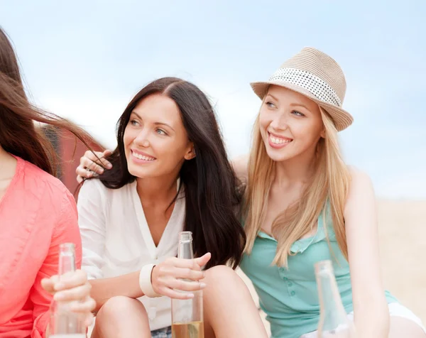 Meisjes met dranken op het strand — Stockfoto