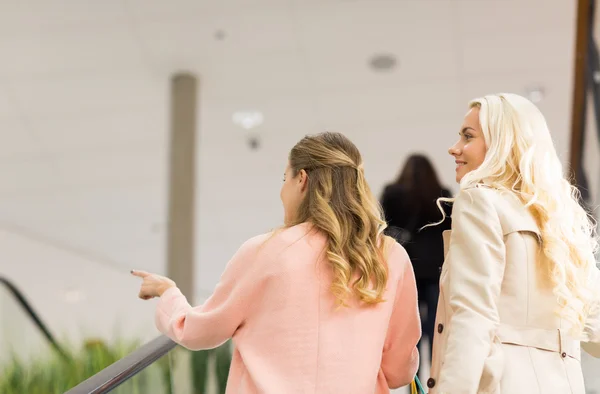 Молоді жінки вказують пальцем на ескалатор в торговому центрі — стокове фото