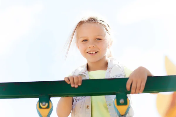 Fröhliches kleines Mädchen klettert auf Kinderspielplatz — Stockfoto