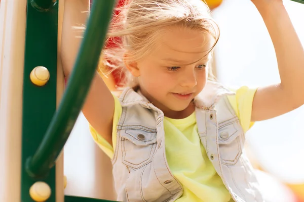 Fröhliches kleines Mädchen klettert auf Kinderspielplatz — Stockfoto