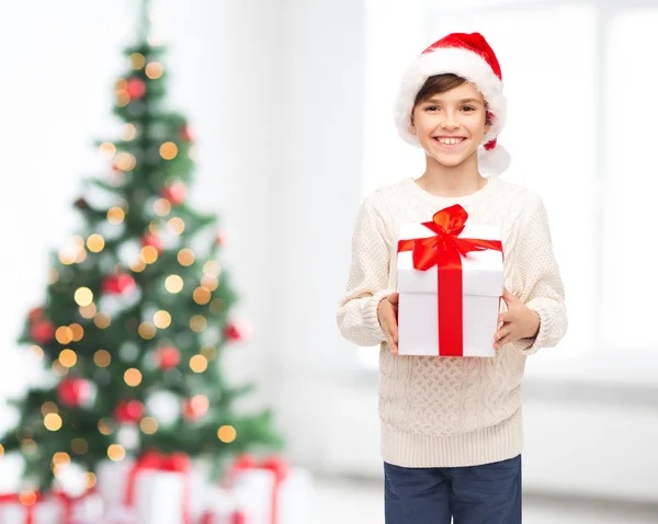 Усміхнений щасливий хлопчик у капелюсі Санта з подарунковою коробкою Стокова Картинка