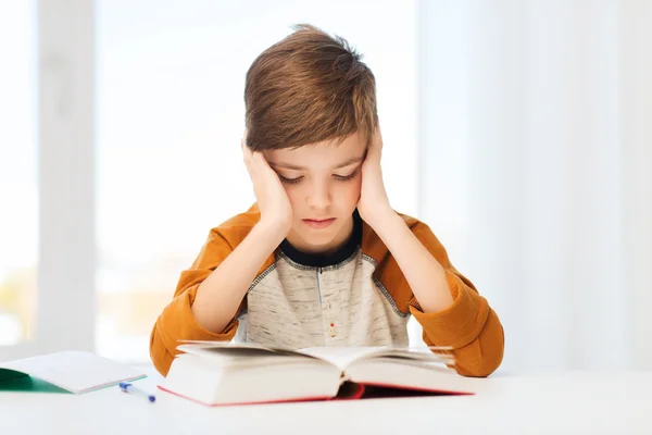Estudante menino ler livro ou livro didático em casa — Fotografia de Stock