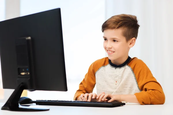 Niño sonriente con computadora en casa — Foto de Stock