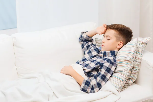 Niño enfermo acostado en la cama y sufriendo de dolor de cabeza —  Fotos de Stock