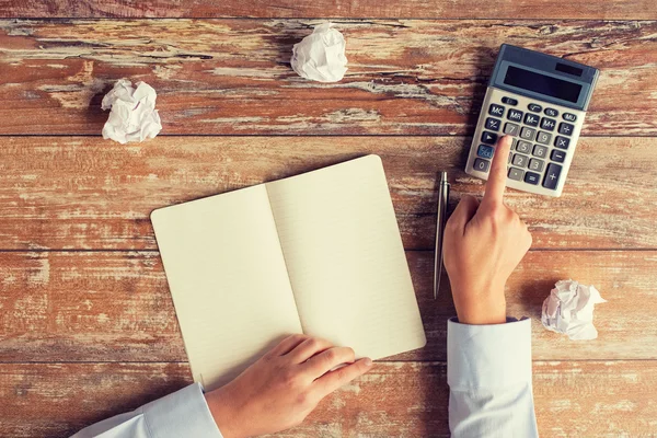 Perto de mãos com calculadora e caderno — Fotografia de Stock