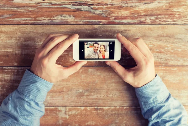 Gros plan des mains masculines avec photo sur smartphone — Photo