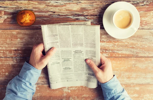 Perto de mãos masculinas com jornal e café — Fotografia de Stock