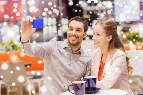 Happy couple with smartphone taking selfie in mall — Stock Photo, Image