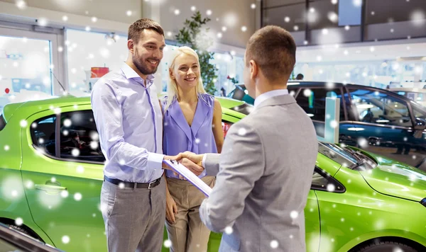 Feliz pareja con concesionario de coches en auto show o salón —  Fotos de Stock